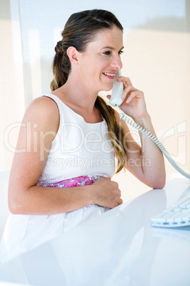 smiling pregnant businesswoman on the phone