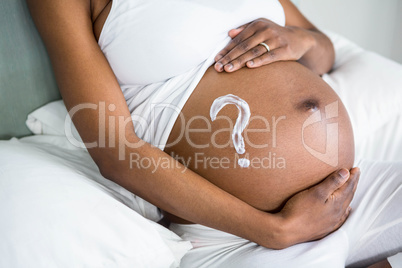 Pregnant woman applying cream on her belly