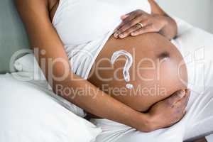 Pregnant woman applying cream on her belly