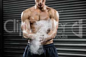 Shirtless man clapping hands with talc