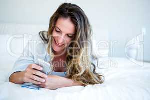 woman lying on her bed listening to music