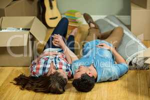 Young couple lying on floor in their new house
