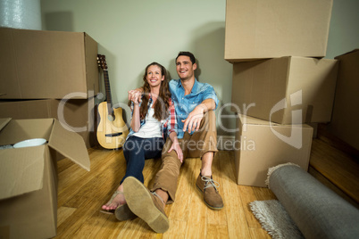 Young couple sitting together on the floor and smiling