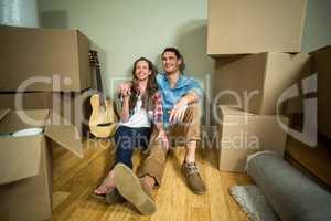 Young couple sitting together on the floor and smiling