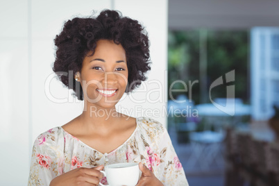 Portrait of smiling woman holding white cup