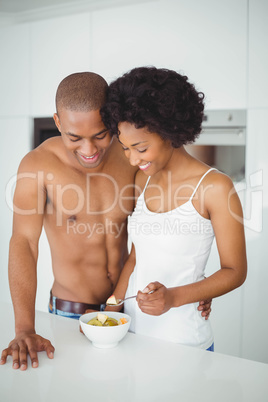 Happy couple  eating fruit together in the kitchen