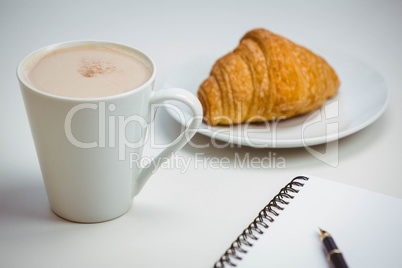 Notebook with pen and coffee by food