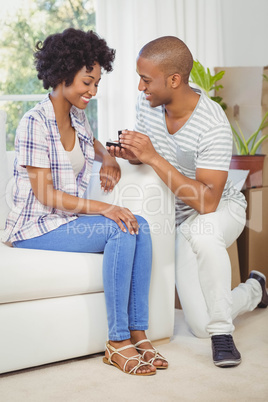 handsome man offering engagement ring to his girlfriend