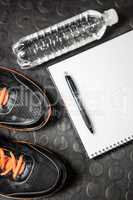 Notepad, shoes and bottle