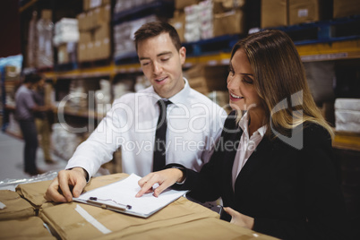 Warehouse managers looking at clipboard