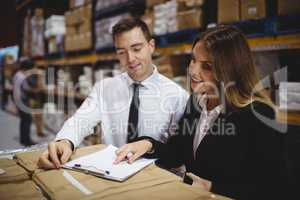 Warehouse managers looking at clipboard