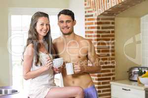Young couple having breakfast in kitchen