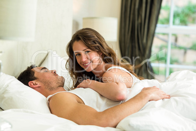 Young couple cuddling on bed