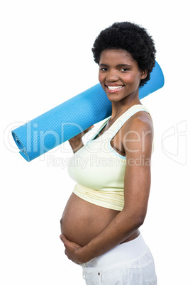 Pregnant woman holding exercise mat