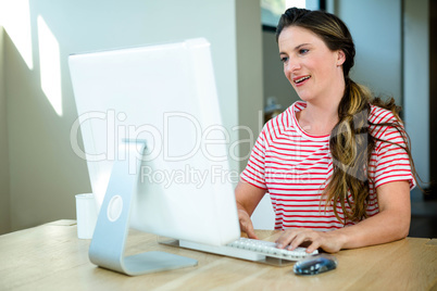 smiling woman sitting at her  computer