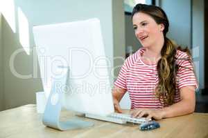 smiling woman sitting at her  computer