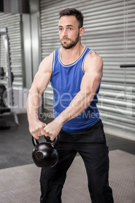 Muscular man lifting kettlebells