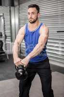 Muscular man lifting kettlebells