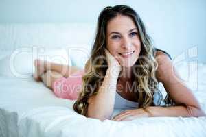 smiling woman relaxing on her bed