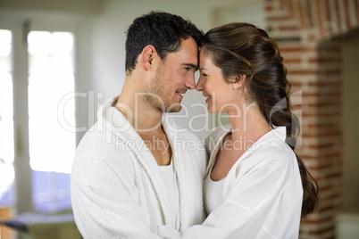 Young couple in bathrobe embracing each other