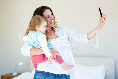 smiling woman taking a selfie with a baby