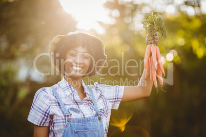 Smiling woman holding carrots