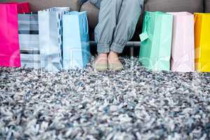 womans feet surrounded by gift bags