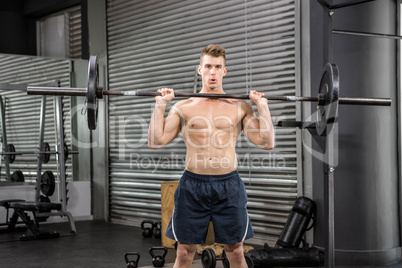 Shirtless man lifting barbell