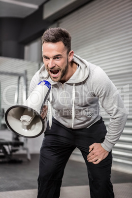 Muscular man shouting on megaphone