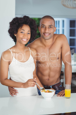 Happy couple eating breakfast in the kitchen