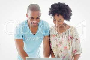 Smiling couple using laptop together