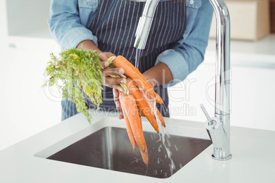 Mid section of man washing carrots