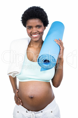 Pregnant woman holding exercise mat