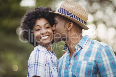 Smiling man kissing her girlfriends cheek