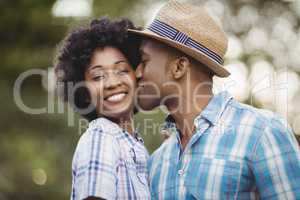 Smiling man kissing her girlfriends cheek