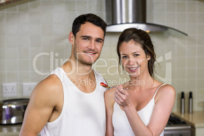 Young woman feeding breakfast to her man