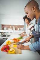 happy couple preparing vegetables