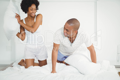 Happy couple having a pillow fight