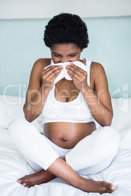 Pregnant woman blowing her nose