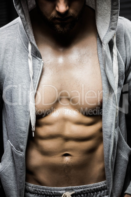 Mid section of shirtless man wearing jumper