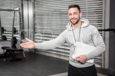 Smiling trainer showing gym to camera