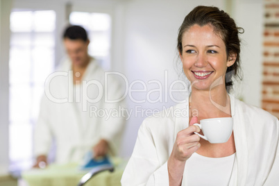 Beautiful woman in bathrobe having a cup of tea