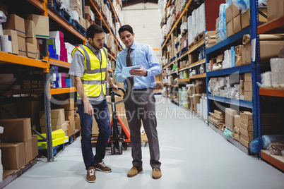 Manager showing tablet to worker