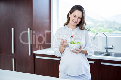 Pregnant woman eating salad