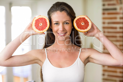 Young woman holding slices of blood orange