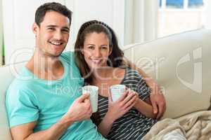 Young couple having coffee on sofa