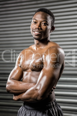 Shirtless man standing with arms crossed