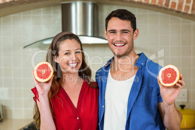 Couple holding slices of blood orange