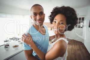Smiling couple embracing in the kitchen
