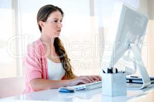 thoughtful businesswoman typing on her computer